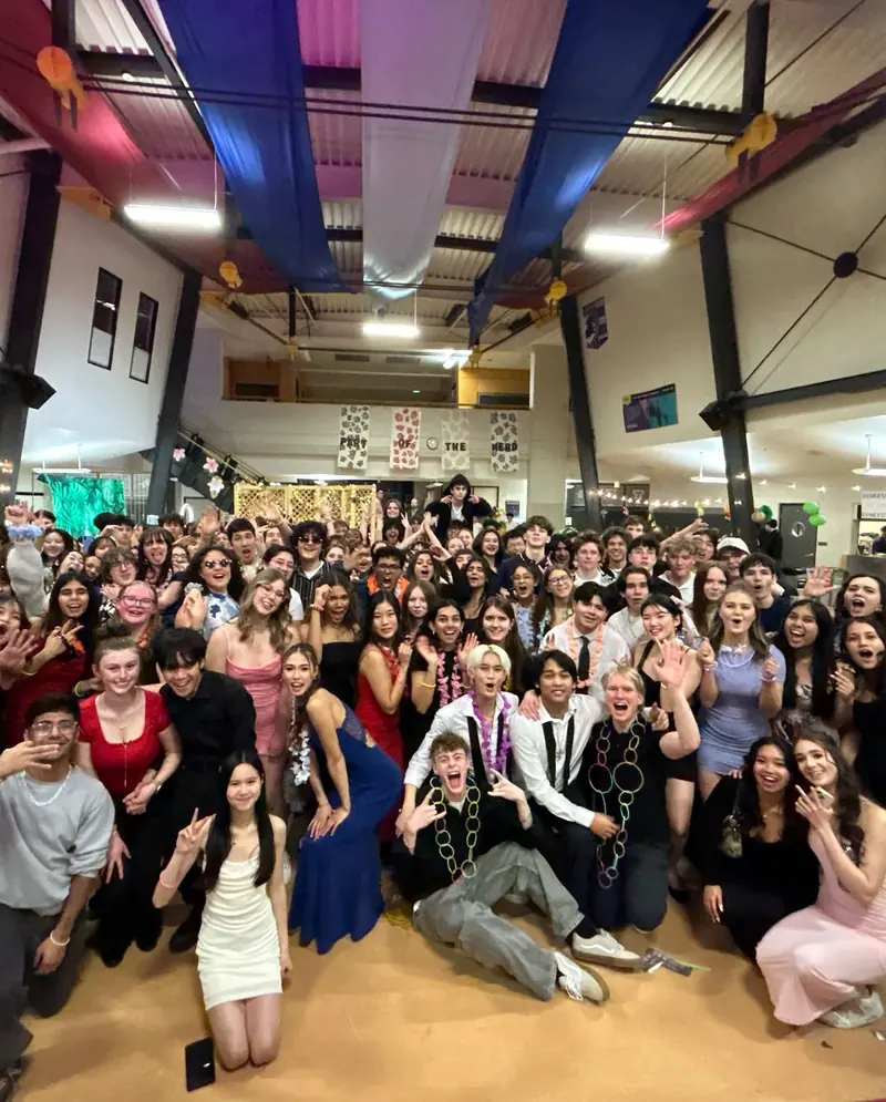 Students cheering for a group photo at their school dance