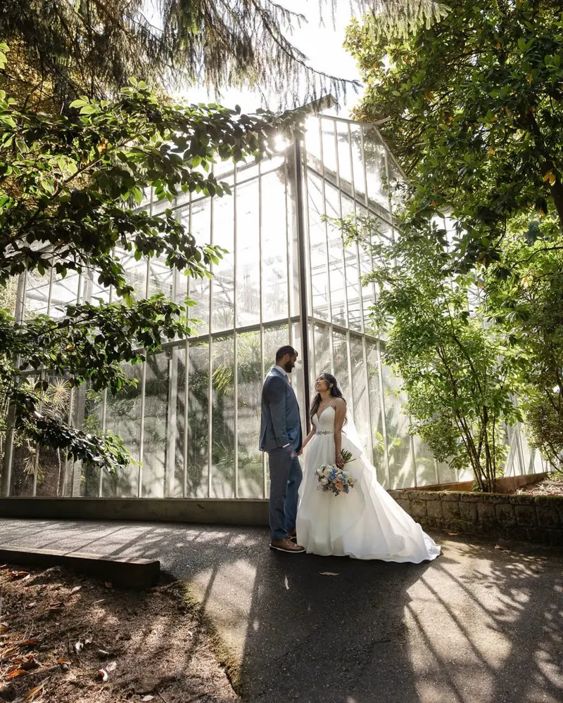 A couple stands outside a glass conservatory