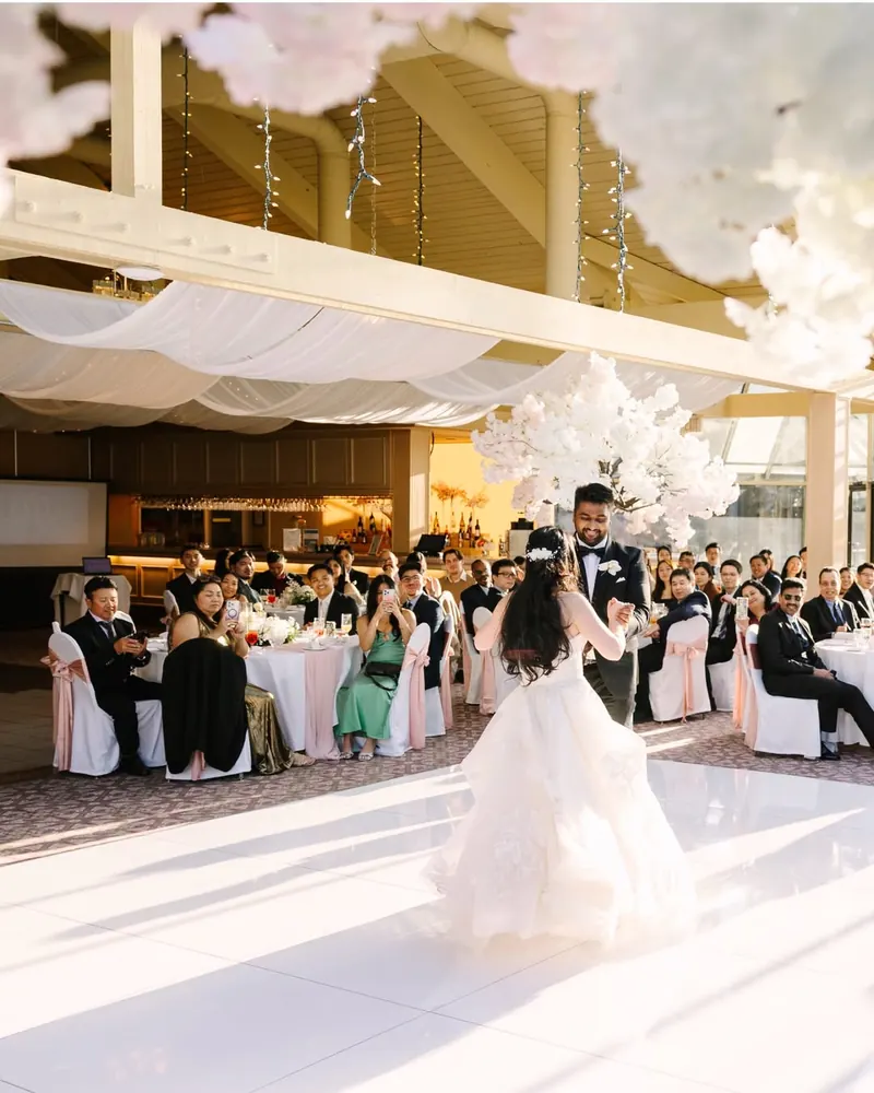Guests watch a couple dance in a glass-roofed reception hall