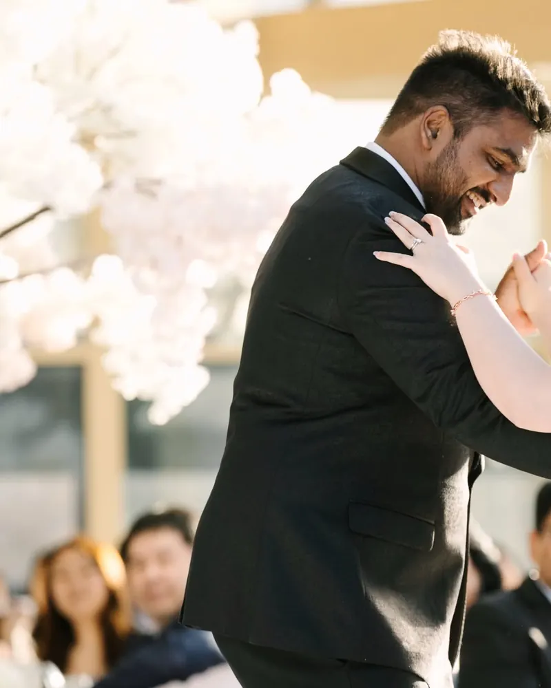 A groom smiles mid-dance at the reception