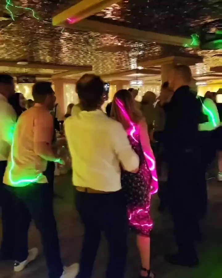 Guests dancing as green and pink laser light sweeps the dance floor